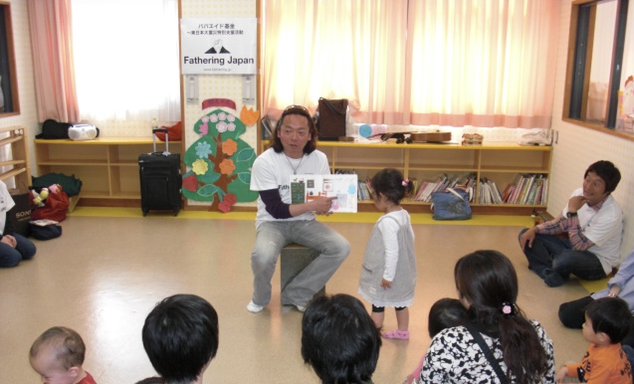 パパエイド基金の活動で代表の安藤哲也が東日本大震災の被災地で子ども向けに絵本の読み聞かせをしている