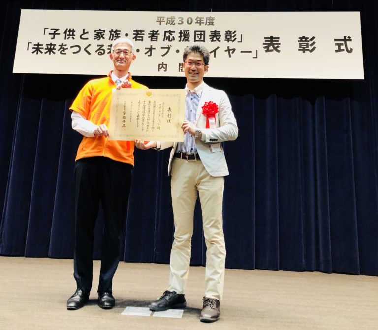 内閣府「子育て支援家庭部門」総理大臣表彰を受けてファザーリング・ジャパンの理事が表彰状を持っている